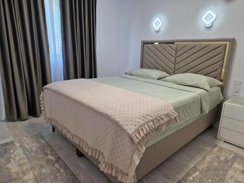 a bedroom with a large bed with a wooden headboard at Apartamente 2026 in Fălticeni