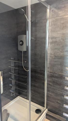 a shower with a glass door in a bathroom at Harestanes Hideaway in Kirkintilloch