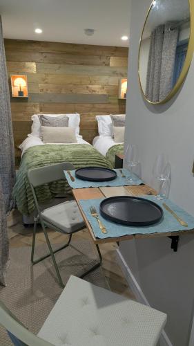 a bedroom with a bed and a table with two mirrors at Harestanes Hideaway in Kirkintilloch