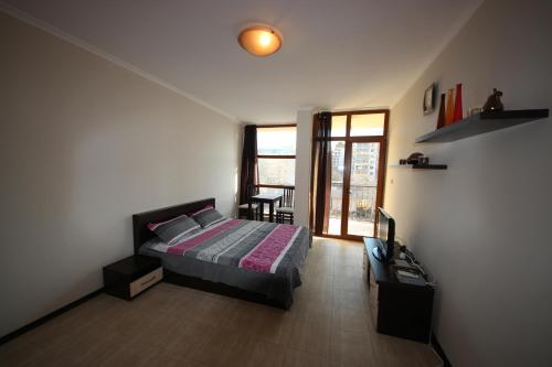 um quarto com uma cama, uma mesa e uma janela em Menada Crystal Park Apartments em Sunny Beach