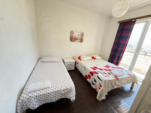 a bedroom with two beds and a window at Old Saranda Apartments in Sarandë