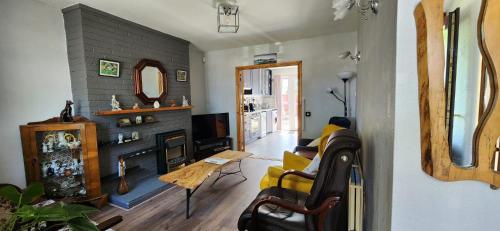 a living room with a fireplace and a yellow couch at Cosy Bungalow in Balbriggan