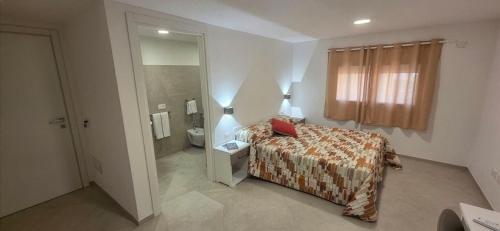 a bedroom with a bed and a bathroom with a toilet at Bardia Guest House in Dorgali