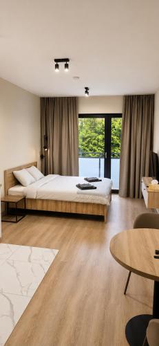 a bedroom with a large bed and a large window at Apartments Rajska 77 in Wrocław