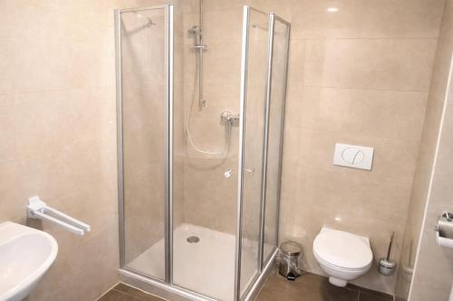 a bathroom with a shower with a toilet and a sink at Check-Inn Hotel - free parking in Offenbach