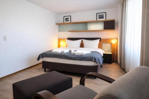 a hotel room with a bed and a couch at Check-Inn Hotel - free parking in Offenbach