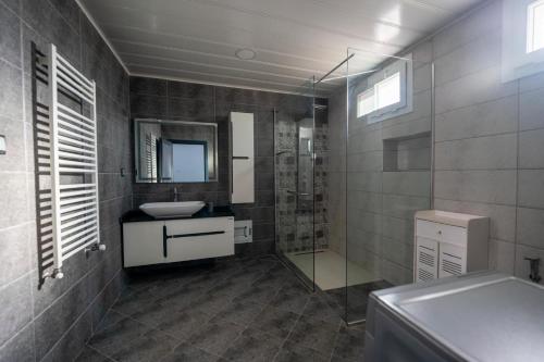 a bathroom with a sink and a glass shower at COLFA STAR Hostel in Bejaïa