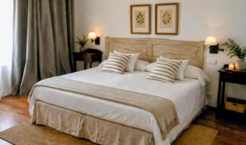 a bedroom with a large white bed with pillows at El Linar in Burgohondo
