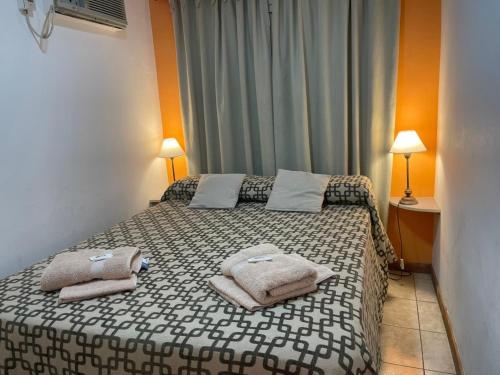 a bedroom with a bed with towels on it at Apart Hotel RioSol in Concepción del Uruguay