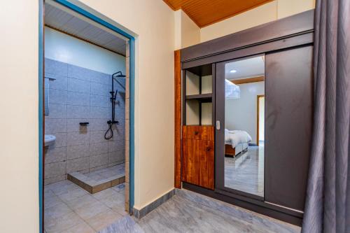 a bathroom with a shower and a glass door at Centre Missionnaire Lavigerie in Kigali