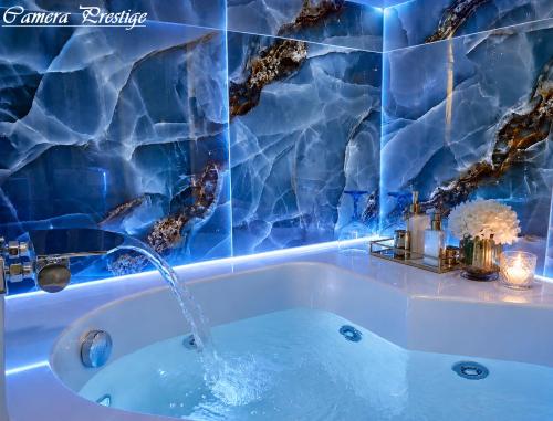 a bathroom with a tub with blue tiles at Dharma Luxury Room in La Spezia