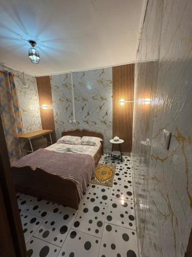 a bedroom with a bed and a tiled floor at Angevita City2 in Edéa