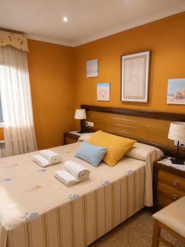 a bedroom with a large bed with two pillows on it at Apartamento Duplex con jardín A Casiña de Divina in Lago