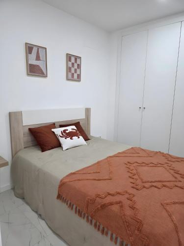 a bedroom with a bed with a brown blanket on it at Casa da Lota in Vieira de Leiria