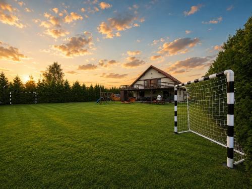 a soccer field with a house in the background at Dom letniskowy Sieraków in Sieraków