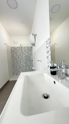 a large white sink in a bathroom with a shower at Torre Antica in Ioppolo
