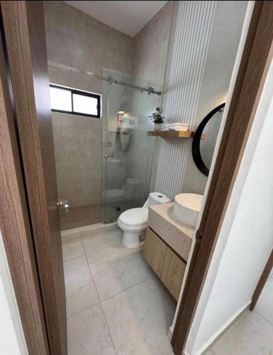 a bathroom with a toilet and a glass shower at By Lumina Parvasa 1 in Ejido Parras