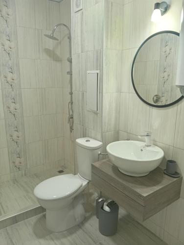a bathroom with a toilet and a sink and a mirror at Kristan in Sveti Vlas