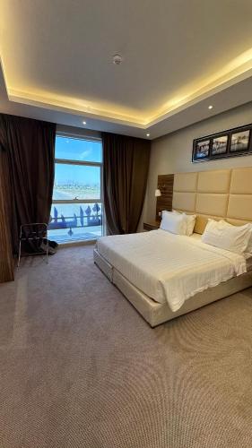 a bedroom with a large bed and a large window at قلب الشمال للشقق الفندقيه in Hail