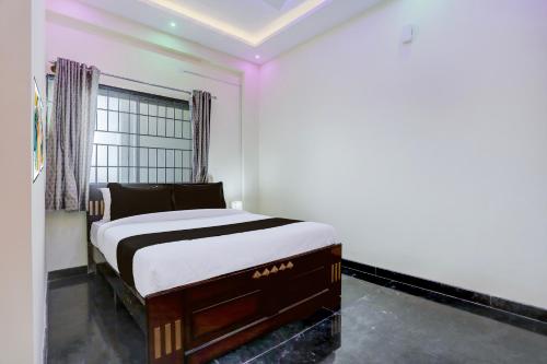a bedroom with a bed in a room with a window at SPOT ON Sri Chowdeshwari Residency in Chik Bānavar