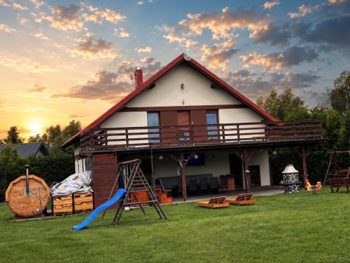 a house with a slide and a playground at Dom letniskowy Sieraków in Sieraków