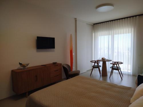 a bedroom with a bed and a tv and a table at Camere DOMOVIEW- design con vista su Cammarata in San Giovanni Gemini