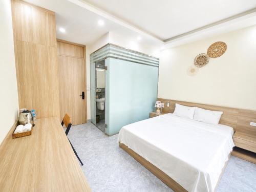 a bedroom with a large white bed and a table at Do Homestay vị trí trung tâm tại Ocean Park 2 in Cửu Cảo