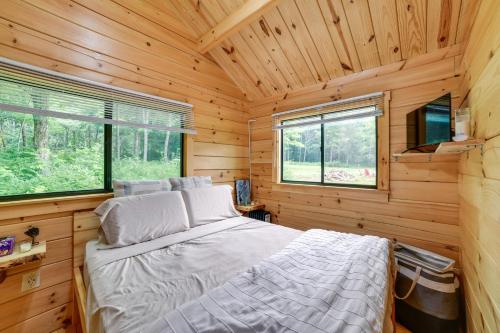 a bedroom with a bed in a wooden cabin at Catskills Tiny Home Cabin: Surrounded by Nature! in Franklin