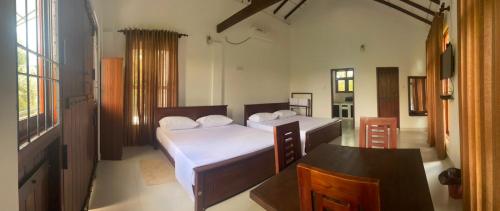 a bedroom with a bed and a table in it at Emerald Mirror in Anuradhapura