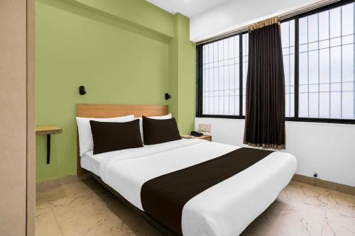 a bedroom with a large bed in a room with windows at Super Collection O MIDC Mahape Mumbai Formerly Hotel Didar House in Mumbai