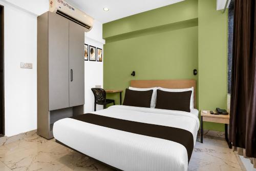a bedroom with a large white bed and a desk at Super Collection O MIDC Mahape Mumbai Formerly Hotel Didar House in Mumbai