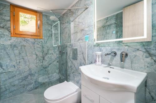 a bathroom with a sink and a toilet and a shower at Lumina House Panagia in Panagia