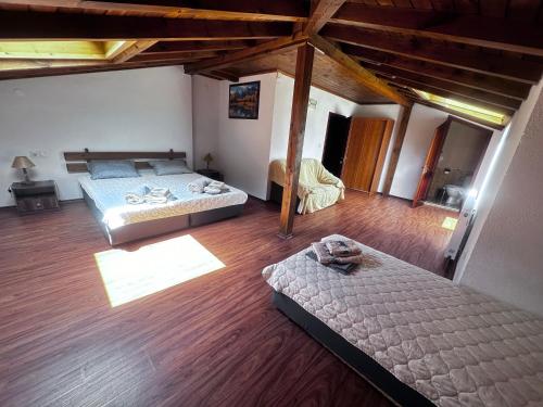 an attic bedroom with two beds and wooden floors at Kulata Predel in Razlog