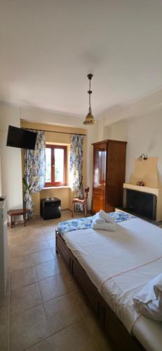 a bedroom with a large bed in a room at Triantafillies Traditional Hotel in Portaria