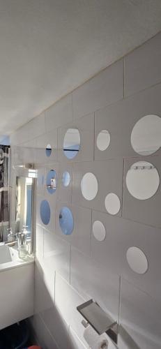 a bathroom with white walls and a sink and a mirror at Chez Misto in Ouangani