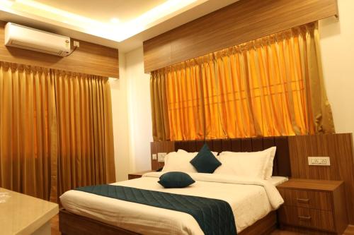 a bedroom with a large bed and a window at Skvr Grand in Theni
