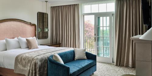 a bedroom with a bed and a chair and a window at Mirbeau Inn & Spa Beacon in Beacon