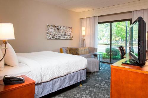 a hotel room with a bed and a television at Courtyard Rochester Brighton in Rochester