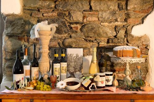 a table with bottles of wine and fruit on it at Abbadia San Giorgio in Moneglia