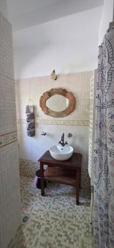 a bathroom with a sink and a mirror at Triantafillies Traditional Hotel in Portaria
