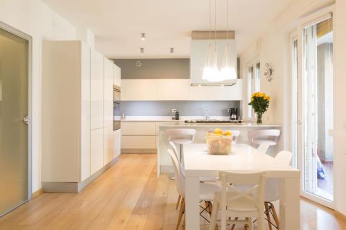 una cucina con tavolo bianco e sedie bianche di Design & Luxury Apartment Verona a Verona