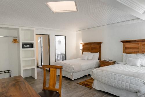 a hotel room with two beds and a table at Hotel La Morada in San Miguel de Allende