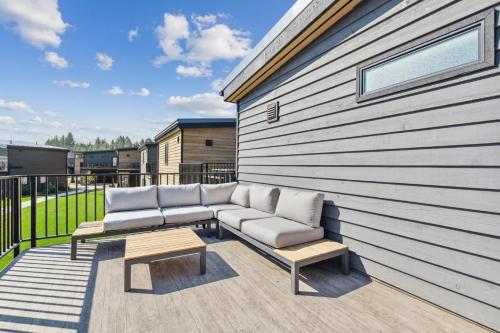 a patio with a couch and two chairs on a building at Quarry A21 in Whitefish