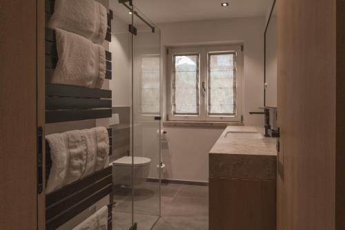 a bathroom with a shower and a sink and towels at Egerner Chalet in Rottach-Egern