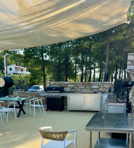 a patio with an outdoor kitchen with a table and chairs at Olea Village in Potos