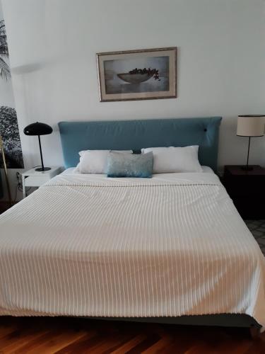 a bedroom with a large bed with a blue headboard at The Stage Door Apartment in Debrecen