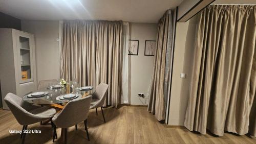 a dining room with a table and chairs and curtains at Casmere Suite in Pomorie