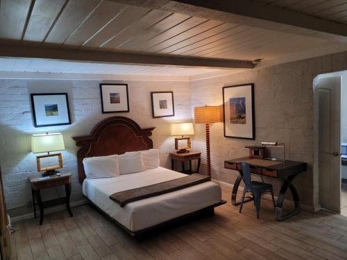 a bedroom with a bed and a desk with two lamps at Sterling Gardens in Las Vegas