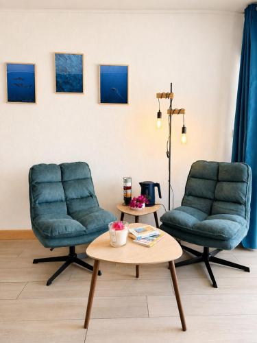 two chairs and a coffee table in a room at Reflet Marin - Studio Village Soleil in Le Gosier