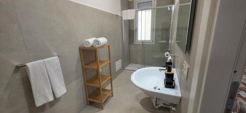 a white bathroom with a sink and a shower at Bardia Guest House in Dorgali